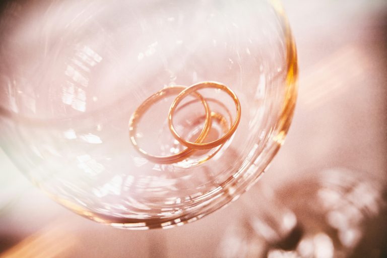 a pair of gold rings in a wine glass