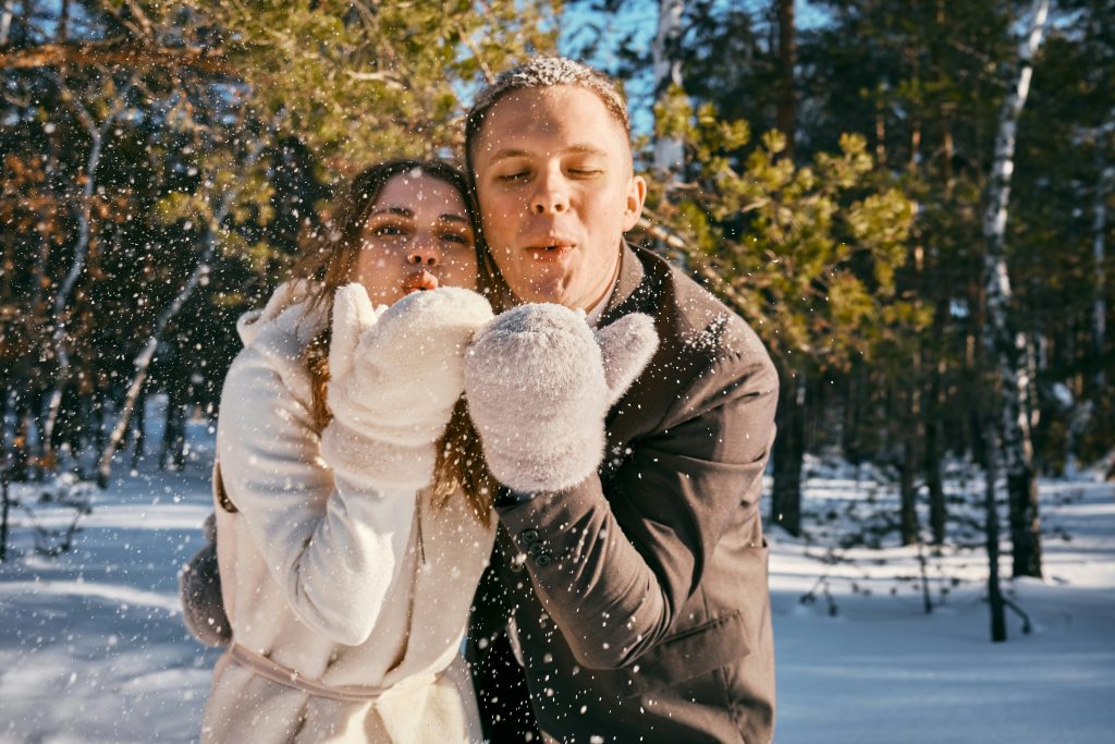 a man and woman blowing snow