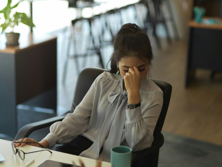 a woman sitting in a chair with her hand on her face