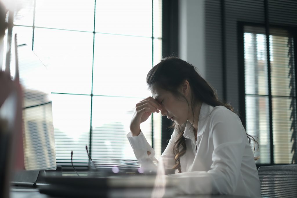 a woman with her hand on her forehead