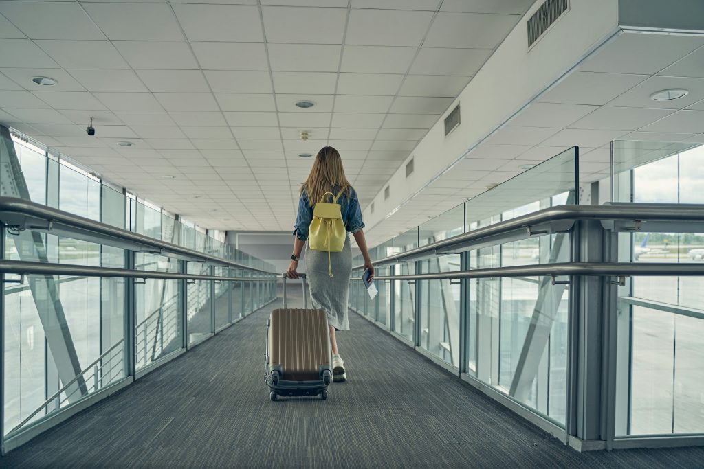 a woman walking down a walkway with a suitcase